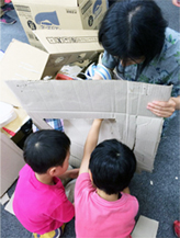 ソダチネ：ダンボールを切り抜く子ども？